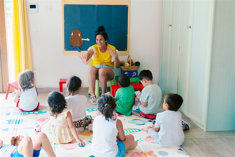 Insegnante madrelingua durante una lezione di inglese con bambini in aula