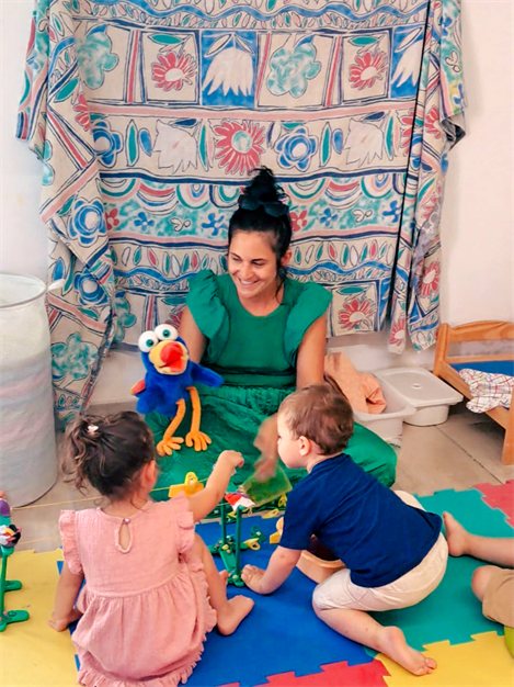 Insegnante con un pupazzo che gioca con i bambini durante la lezione di inglese